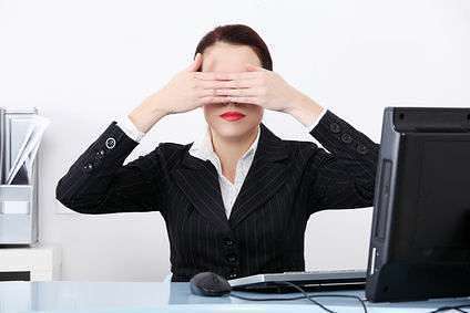 Businesswoman at office covering her eyes.