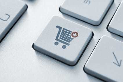 Button with shopping cart icon on a modern computer keyboard.